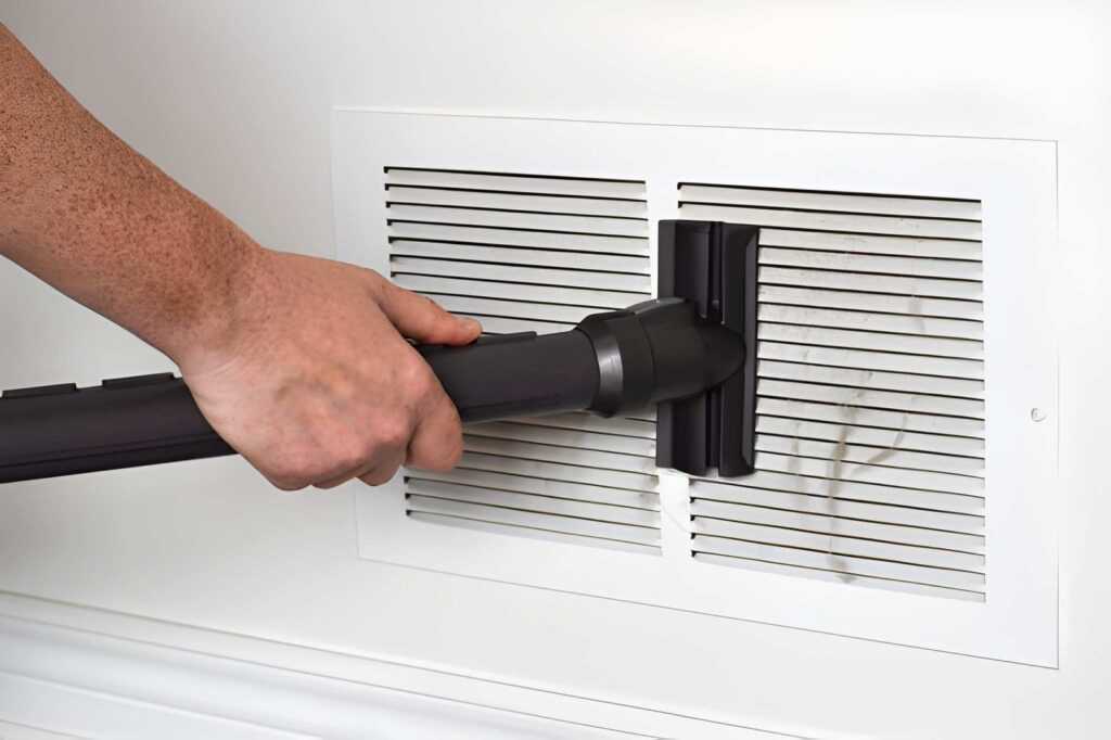 Technician performing duct cleaning in a modern home to improve HVAC efficiency and indoor air quality.